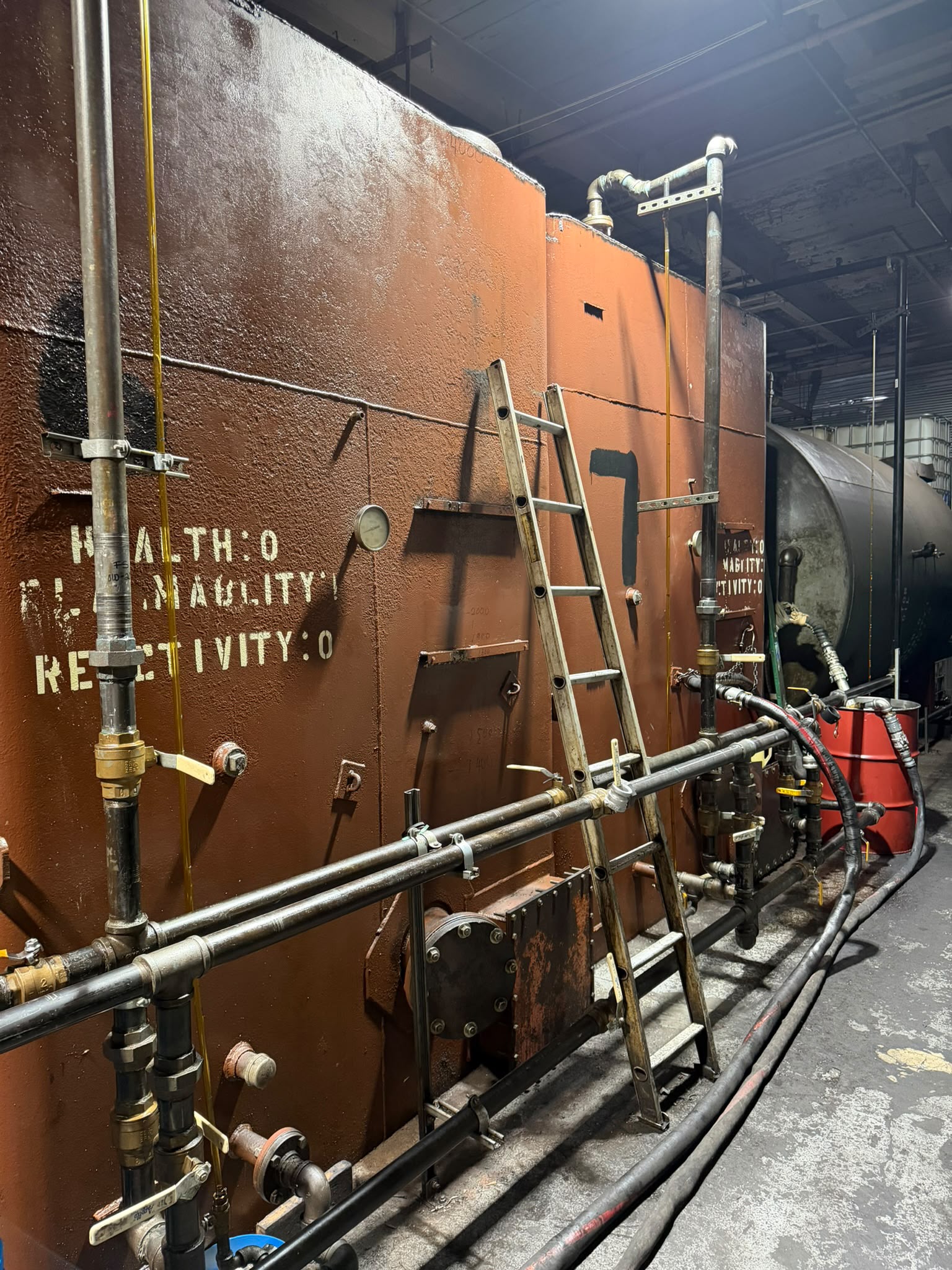 Orange blending tanks with a ladder at the Bass Oil facility
