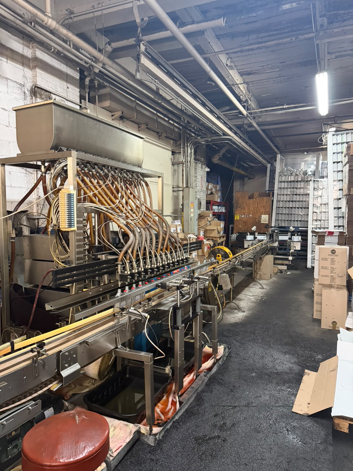 Close-up of the multi-head filling machine at Bass Oil with hoses and nozzles