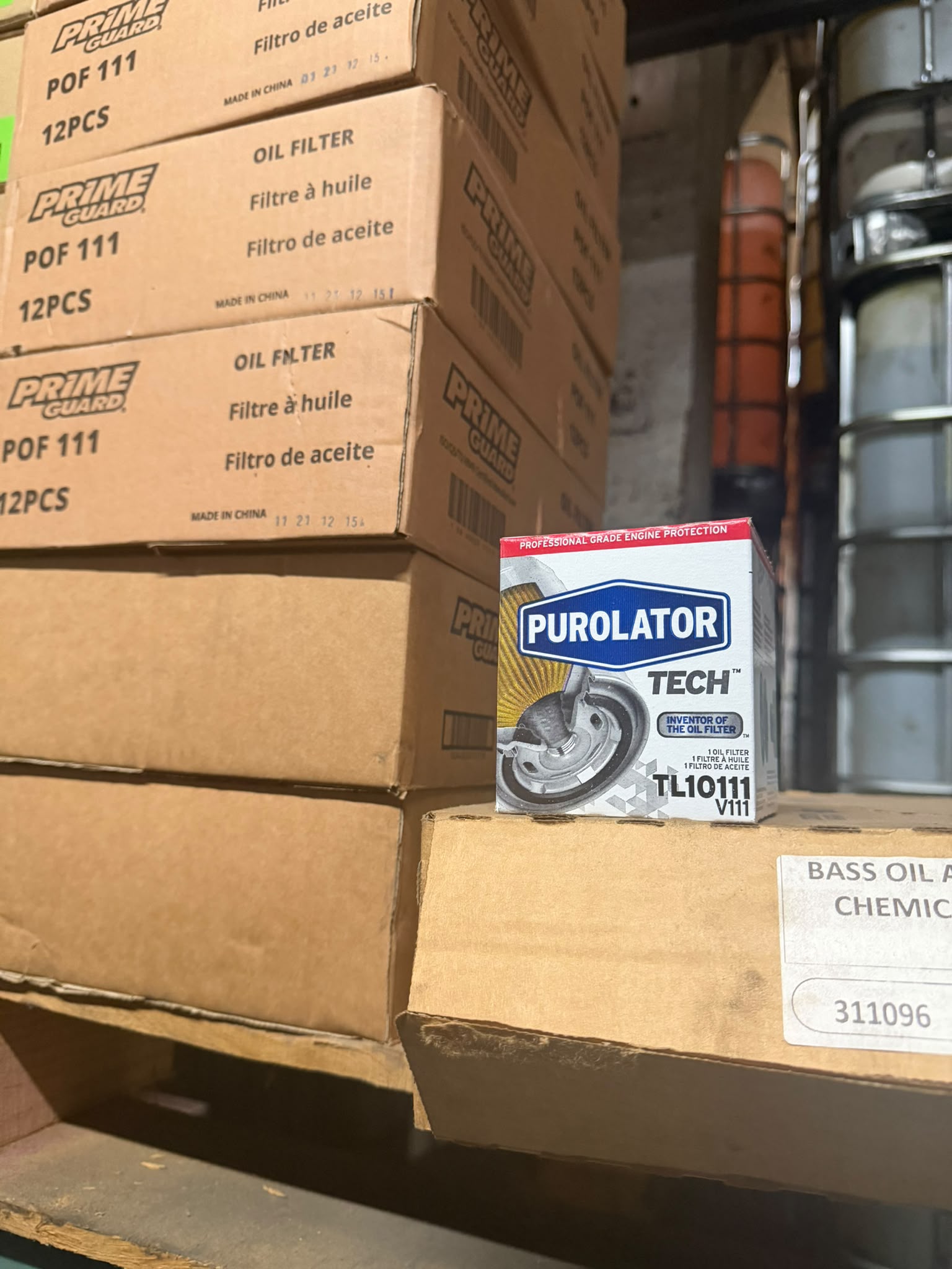 Prime Guard POF 111 oil filter cases and a Purolator TECH TL10111 oil filter on the shelf at the Bass Oil warehouse in Brooklyn